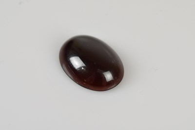 Lot 53 - LOOSE GEMSTONES; an oval cut garnet cabochon...