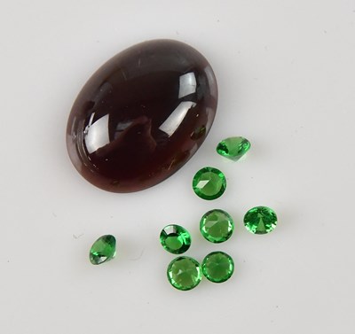 Lot 266 - LOOSE GEMSTONES; an oval cut garnet cabochon...