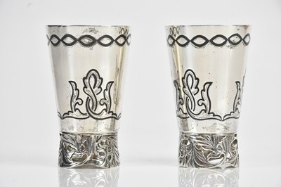 Lot 382 - Two white metal and black enamel tot cups,...