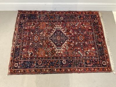 Lot 277 - An eastern rug with abstract motifs on a red...