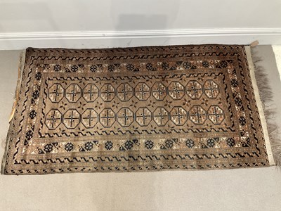 Lot 284 - An eastern brown ground rug with elephant foot...