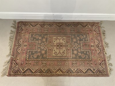 Lot 276 - An eastern rug with stylised detail on a pink...