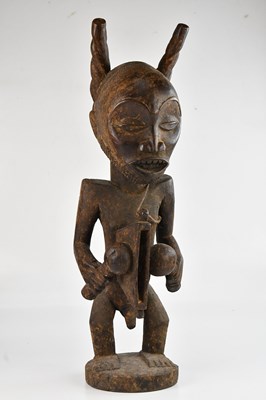 Lot 1181 - A carved wooden Congolese figure with a drum,...