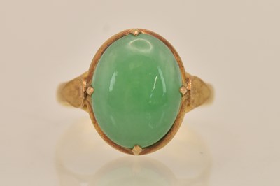 Lot 1289 - A Chinese yellow metal oval green jade set...