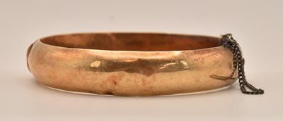 Lot 1493 - A 14K yellow gold hinged snap bangle, diameter...