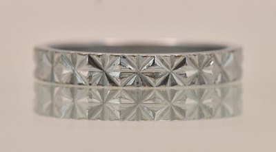 Lot 1331 - A Chinese white metal band ring, stamped '18K'...
