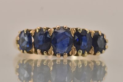 Lot 1254 - A yellow metal sapphire set five stone ring,...