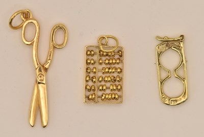 Lot 1398 - Three 14ct yellow gold charm pendants...