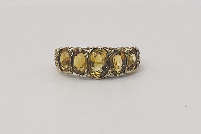 Lot 662 - A 9ct yellow gold citrine set five stone ring,...