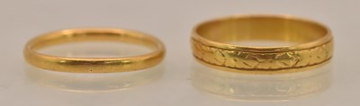 Lot 1243 - A 22ct yellow gold band ring, size P, and a...