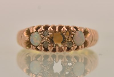 Lot 1296 - A 22ct yellow gold ring with three opals (one...