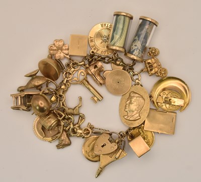 Lot 1488 - A 9ct yellow gold charm bracelet, with an...