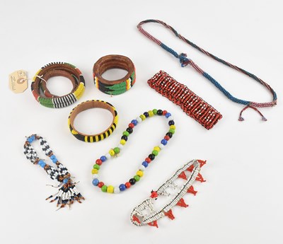 Lot 1182 - A collection of four Zulu beaded bangles, with...