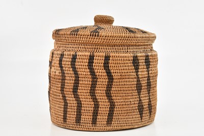 Lot 1174 - A North African hand woven cylindrical basket...