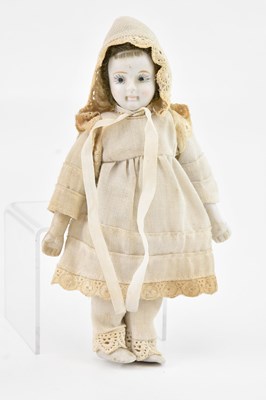 Lot 2367 - A small porcelain headed doll, in traditional...