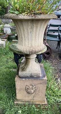 Lot 2151 - A reconstituted stone garden urn on associated...
