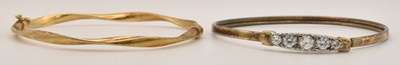 Lot 1436 - A gold plated bangle, set with five graduated...