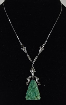 Lot 1469 - A Chinese carved green jade pendant with...