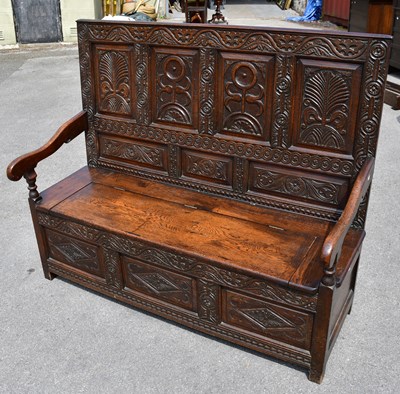 Lot 1656 - An oak settle with carved four panel back and...