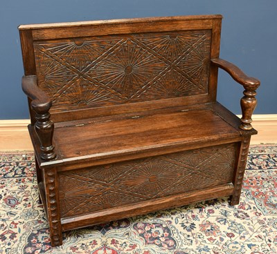 Lot 1662 - A carved oak settle with hinged seat, height...