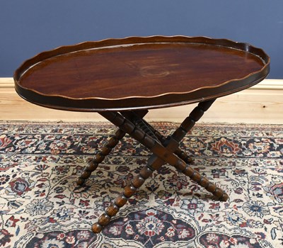 Lot 1647 - A mahogany tray-top table on folded base,...