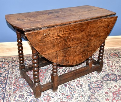 Lot 1583 - An 18th century oak oval drop-leaf gateleg...