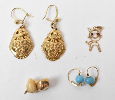 Lot 687 - A pair of yellow metal earrings, two teeth set...