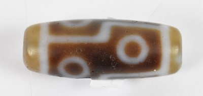 Lot 618 - A Tibetan old agate eye motif dzi bead, length...