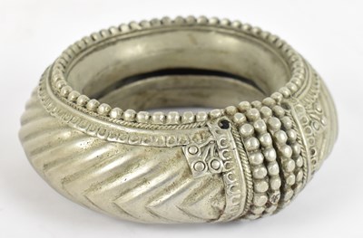 Lot 668 - A large Eastern white metal bangle, diameter...
